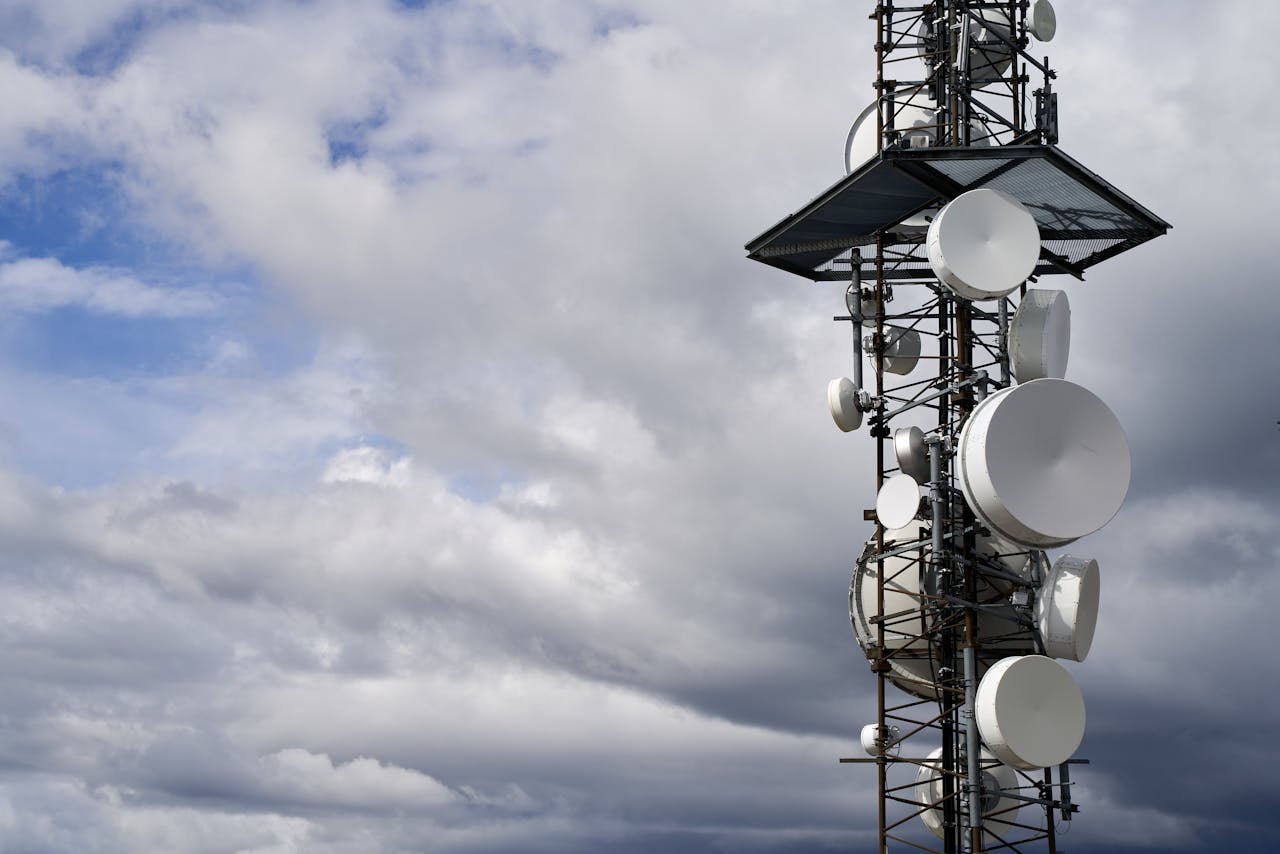 my-path A telecommunication tower equipped with satellite dishes against a cloudy sky.