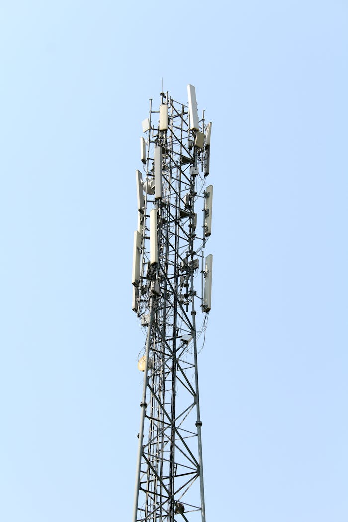A tall cell tower in Tirupati, transmitting signals under a clear blue sky.