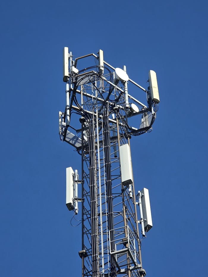 Close-up of a telecom tower under a clear blue sky, emphasizing connectivity.