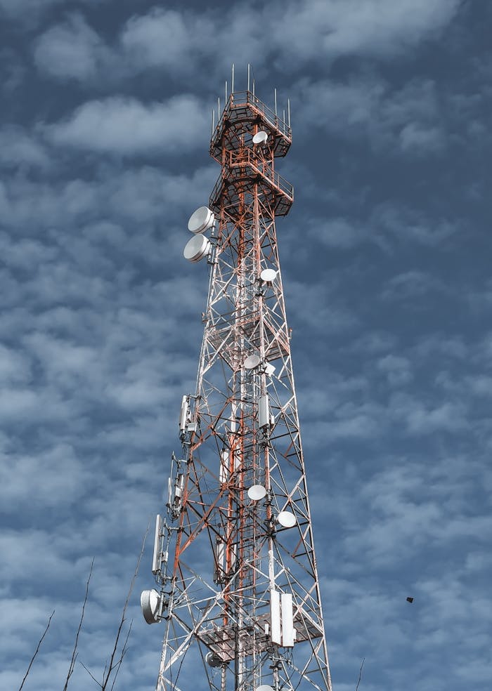 A telecommunications tower reaching into the cloudy sky, showcasing modern technology infrastructure.